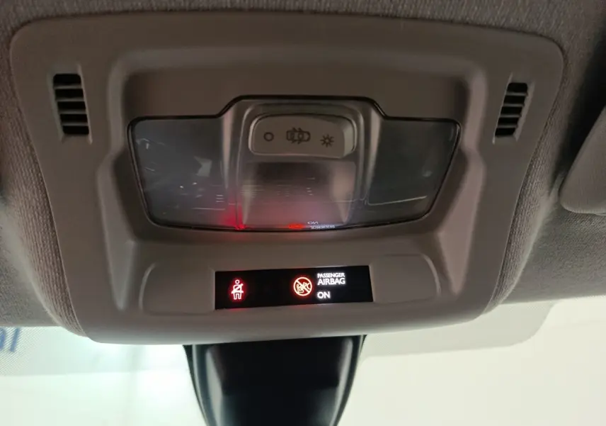 Vue intérieure du plafonnier de la Citroën C3 2024 avec indicateurs lumineux d'airbag passager activé.