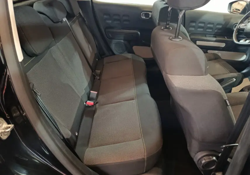 Vue intérieure côté gauche montrant la banquette arrière noire et les sièges avant du Citroën C3 2024.