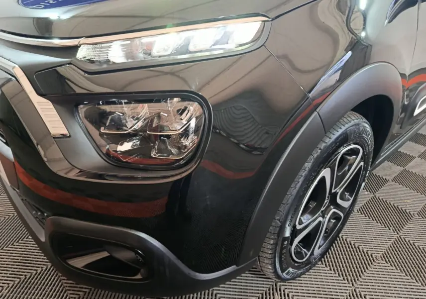 Gros plan sur l'avant droit noir brillant d'une Citroën C3 2024 avec phares LED et jante alliage distinctive.