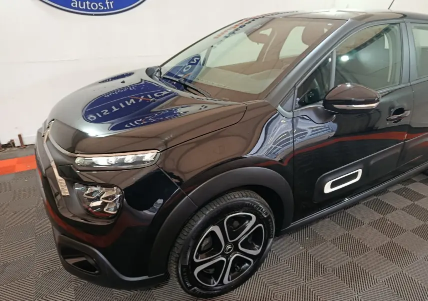 Vue 3/4 avant droite d'une Citroën C3 noire 2024 avec phares LED et jantes distinctives au design moderne.