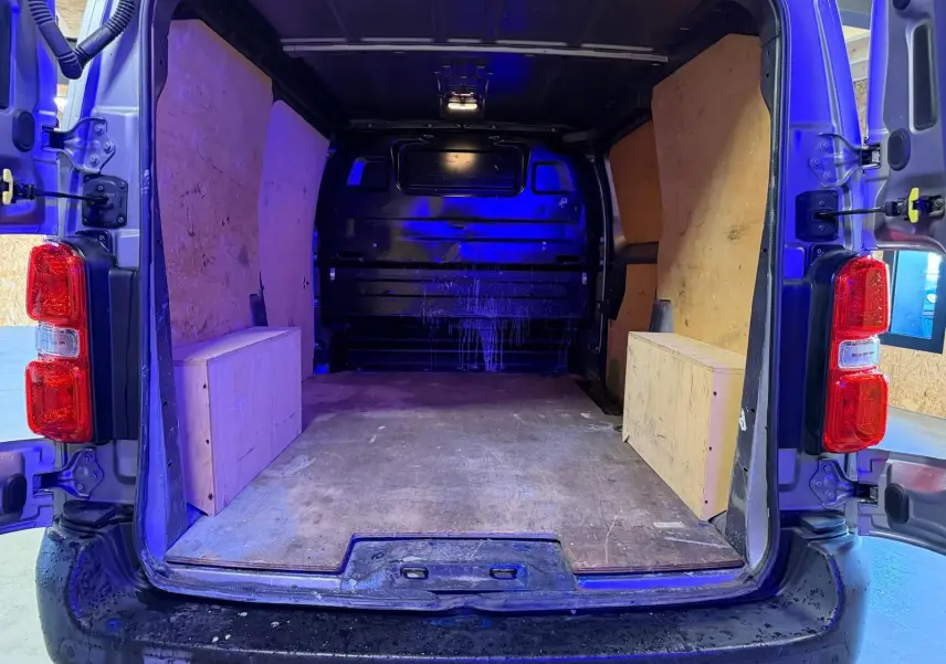 Vue arrière du Citroën Jumpy gris 2022 avec portes battantes ouvertes montrant l’espace de chargement vide et plancher en bois.