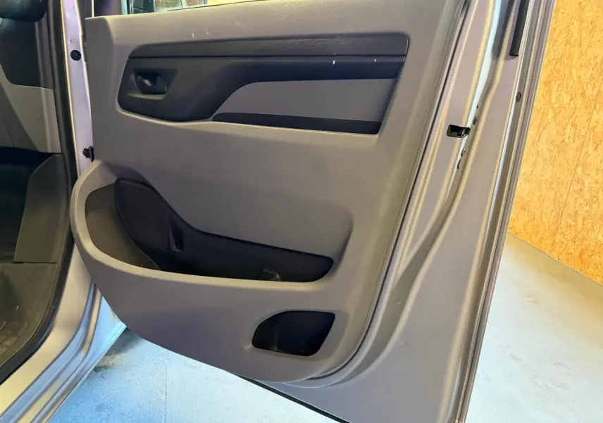 Gros plan sur la porte latérale droite grise du Citroën Jumpy 2.0 BlueHDi 180 EAT avec compartiments de rangement intégrés.