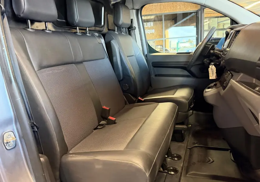 Vue intérieure côté conducteur du Citroën Jumpy 2.0 BlueHDi 180 2022, montrant les sièges avant en tissu noir.