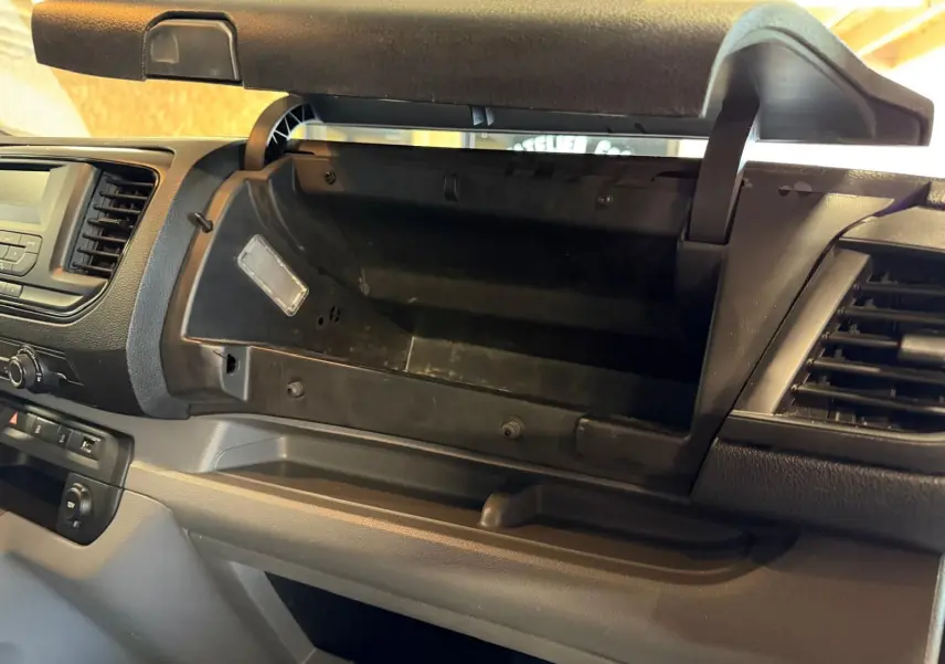 Intérieur du Citroën Jumpy 2.0 BlueHDi 180 2022, vue sur la boîte à gants ouverte et tableau de bord gris.