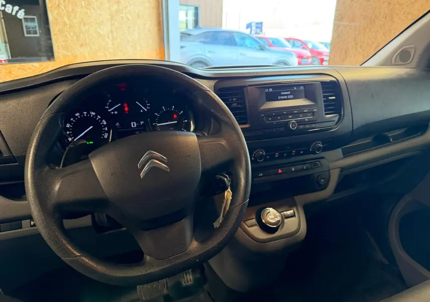 Vue intérieure du poste de conduite du Citroën Jumpy gris 2022, avec volant, tableau de bord et console centrale visibles.