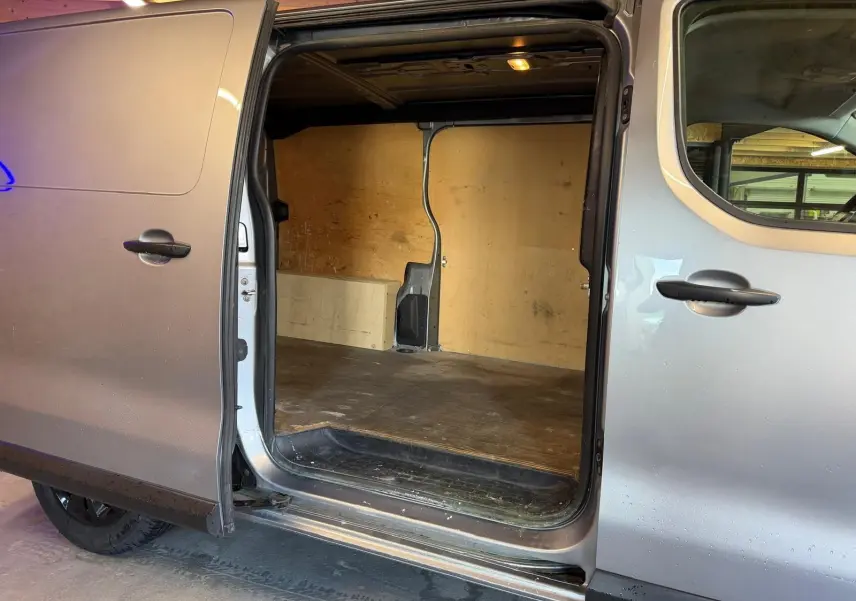 Vue latérale gauche d'un Citroën Jumpy gris 2022 avec porte latérale coulissante ouverte montrant l'espace de chargement.