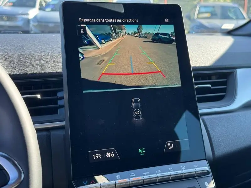Écran central du Renault Captur 2025 montrant la caméra de recul avec lignes de guidage colorées, intérieur noir.