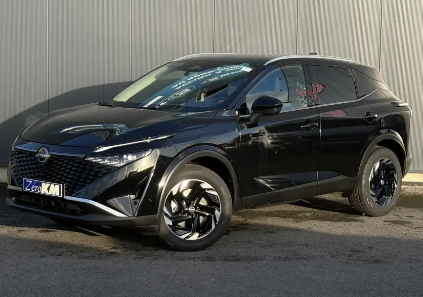 Nissan Qashqai noir Kuro en 3/4 avant droit, avec jantes alliage noires et calandre distinctive brillante.