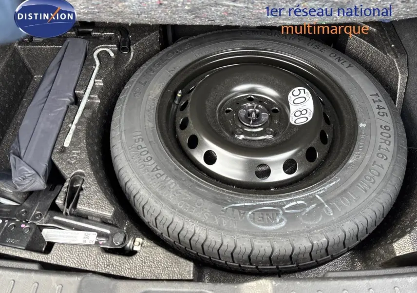 Roue de secours et outils de bord dans le coffre d'un Nissan Juke 1.6 HEV gris perle métal 2024.