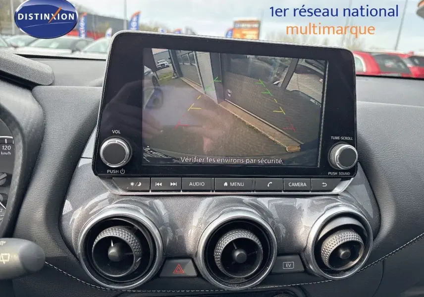 Vue intérieure du tableau de bord du Nissan Juke gris perle métal 2024, écran multimédia affichant la caméra de recul.