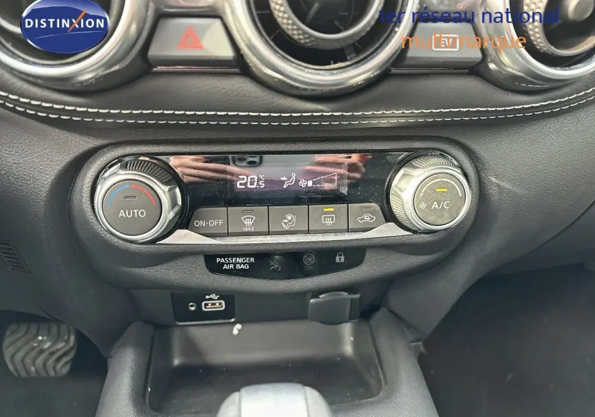 Tableau de bord du Nissan Juke 2024 gris perle, vue centrée sur la console de climatisation automatique avec affichage digital.