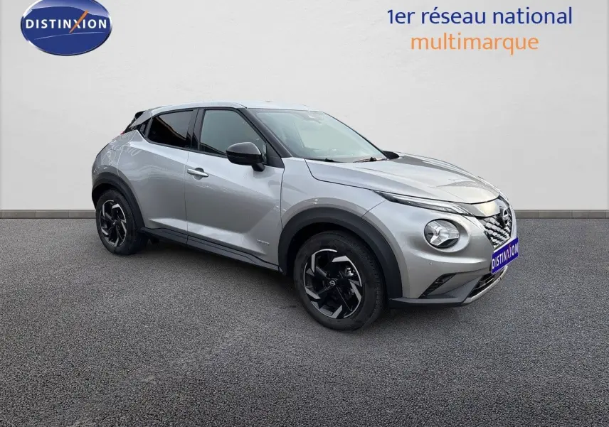Nissan Juke gris perle métal vu de trois quarts avant droit, avec jantes noires et toit noir contrastant.