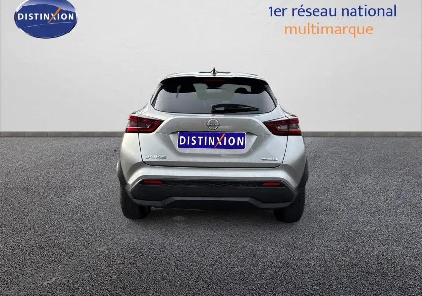 Vue arrière d'un Nissan Juke 2024 gris perle métal, version hybride N-Connecta avec logo Distinxion visible.