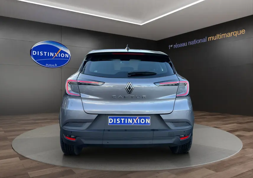 Vue arrière d’un Renault Captur 2024 gris Cassiopée avec toit noir, mettant en valeur ses feux LED et caméra de recul.