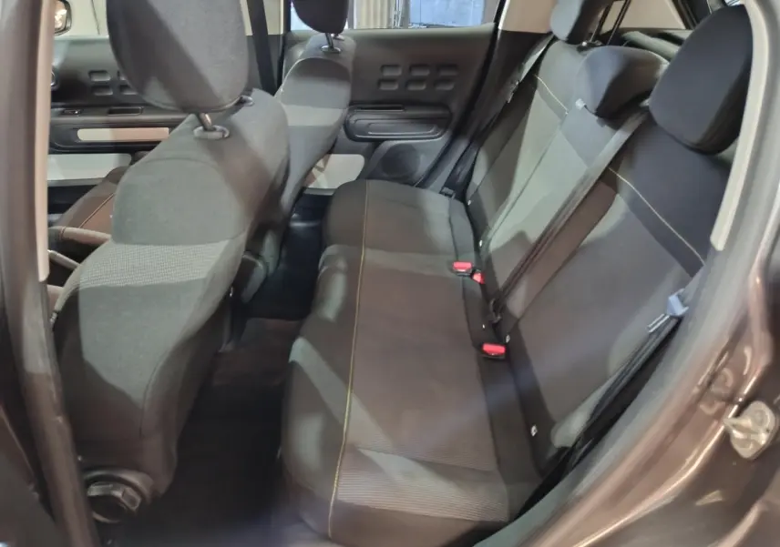 Vue intérieure côté arrière droit de la banquette arrière grise foncée de la Citroën C3 2024 avec détails des sièges et ceintures.