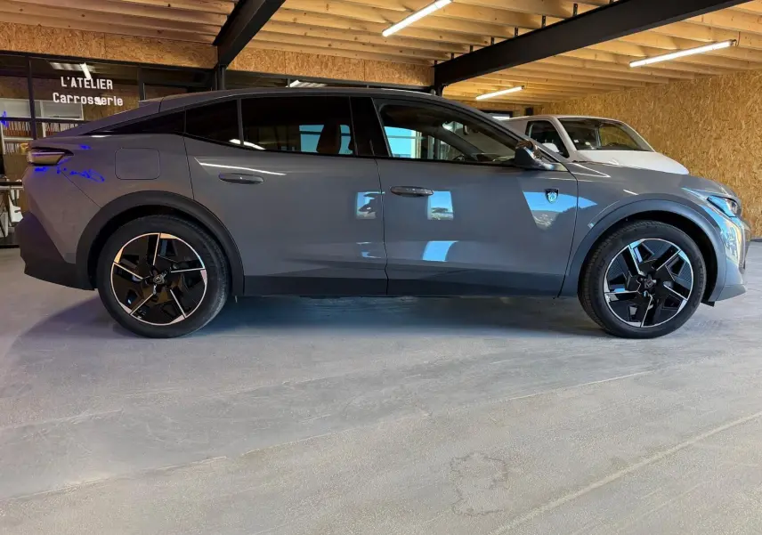 Vue latérale droite d'une Peugeot 408 gris Selenium avec jantes 19'' diamantées graphite et toit noir Mistral.