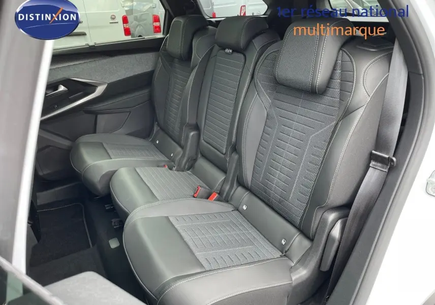 Vue intérieure côté droit des sièges arrière en cuir noir avec surpiqûres blanches du Peugeot 5008 Hybrid 2025 blanc toit noir.