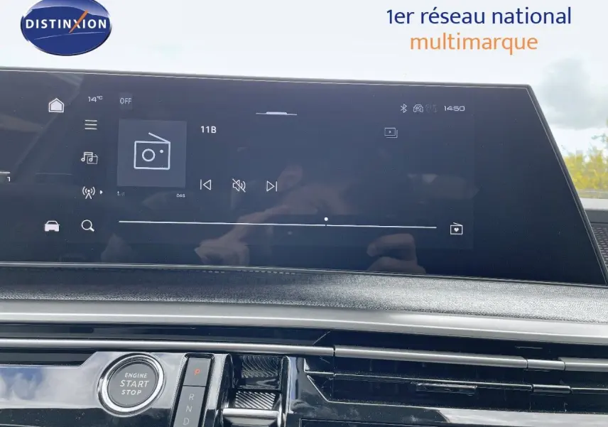 Vue rapprochée de la console centrale du Peugeot 5008 Hybrid 2025 avec écran tactile et bouton start/stop.