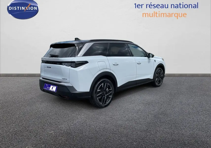 Vue 3/4 arrière droite du Peugeot 5008 hybride blanc Okenite avec toit noir et jantes noires distinctives.