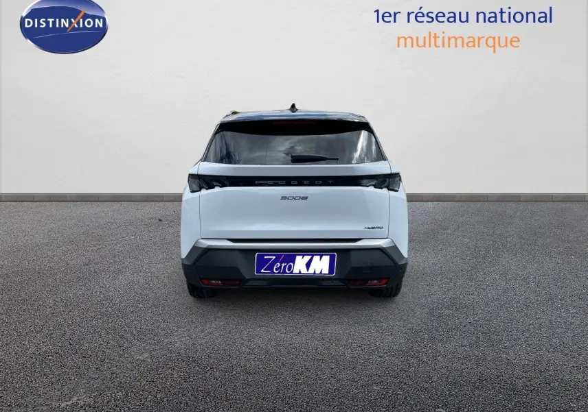 Vue arrière d'un Peugeot 5008 hybride blanc Okenite métal avec toit noir, immatriculé Zéro KM, sur sol gris.