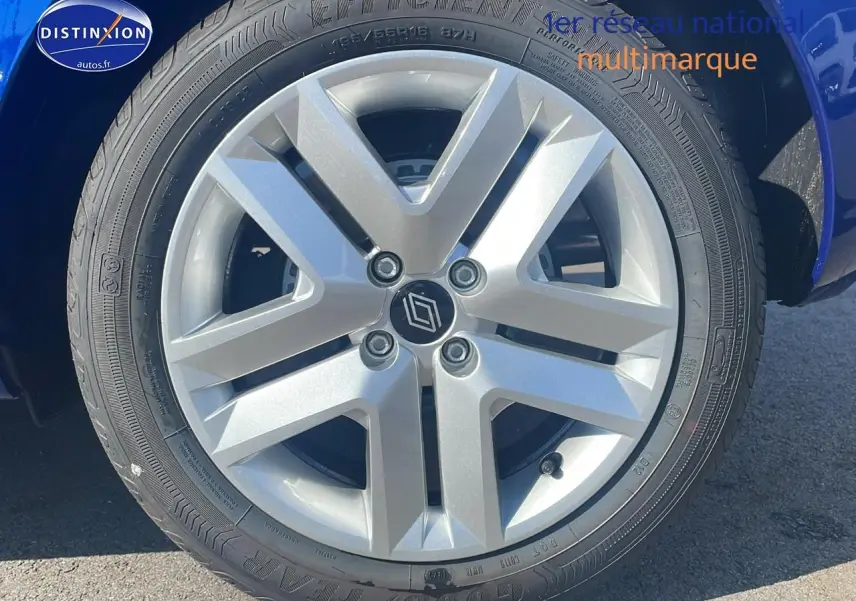 Gros plan sur la roue avant gauche d'une Renault Clio V bleu iron, mettant en valeur la jante alliage et le logo central Renault.