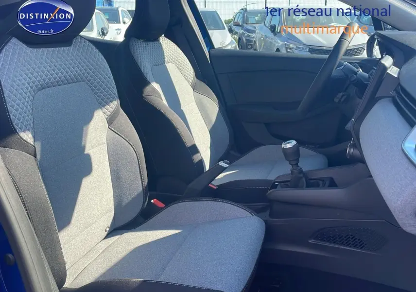 Intérieur avant droit de Renault Clio V bleu iron 2025, sièges tissu bicolore et boîte manuelle visible
