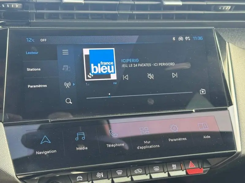 Écran tactile central de la Peugeot 308 2024 affichant la radio France Bleu, avec commandes multimédia en dessous.