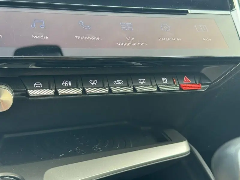 Détail des commandes de la console centrale avec écran tactile, boutons de fonction et bouton d’alerte rouge dans une Peugeot 308 gris Artense.