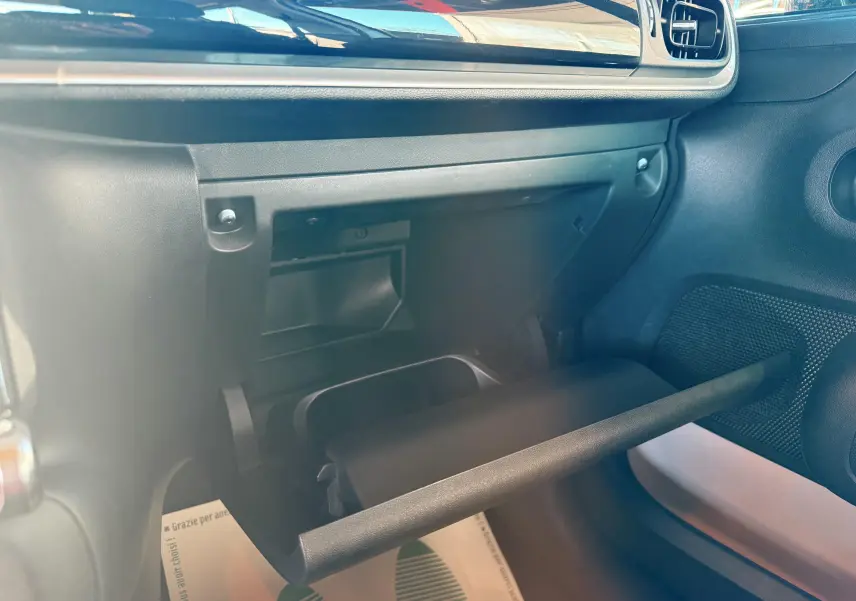 Intérieur de la Citroën C3 2017, vue du coffre à gants ouvert côté passager avec tableau de bord noir.