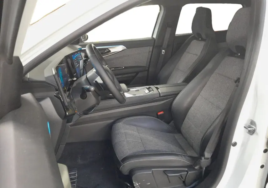 Vue intérieure côté conducteur du Renault Espace blanc nacré 2025, sièges tissu gris et tableau de bord numérique.