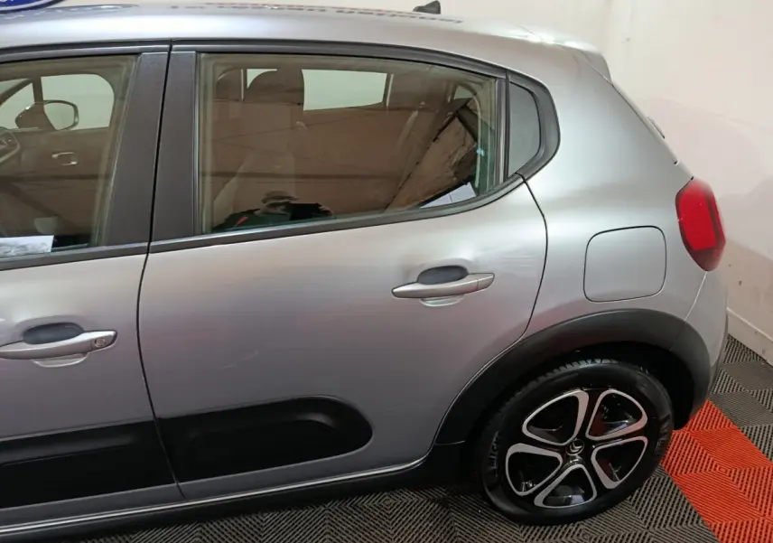 Vue latérale droite d'une Citroën C3 gris clair 2024, avec protections noires et jantes alliage distinctives.