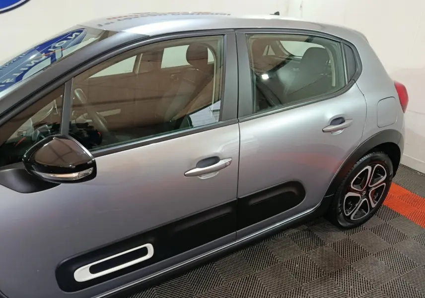 Vue latérale droite d'une Citroën C3 gris clair avec protections de porte noires et jantes stylisées.