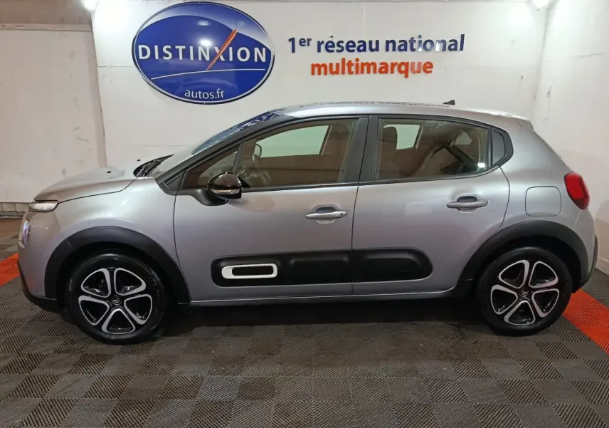 Vue de profil côté gauche d'une Citroën C3 gris clair 2024 avec protections latérales noires et jantes stylisées.