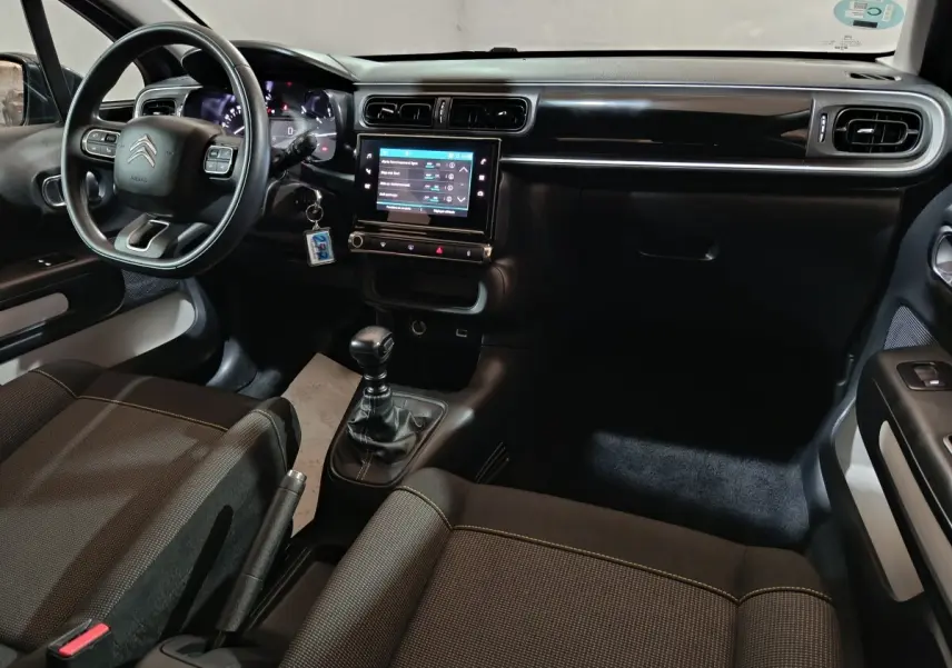 Intérieur du Citroën C3 2024 Diesel, vue de l'habitacle côté conducteur avec tableau de bord noir et écran tactile central.
