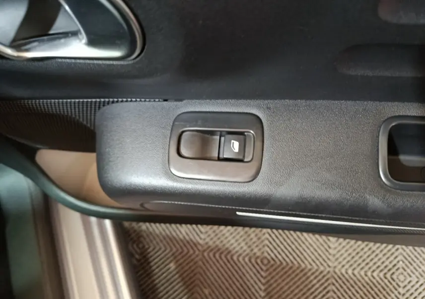 Bouton de commande de la vitre électrique sur la porte côté conducteur du Citroën C3 gris clair 2024.