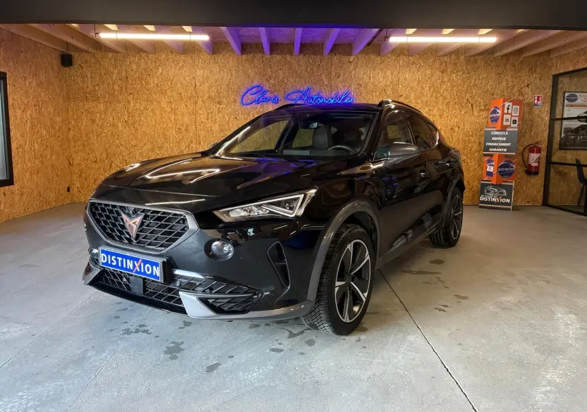 Vue 3/4 avant d'un CUPRA Formentor noir 2022 avec jantes alu et calandre au logo cuivre dans un showroom.