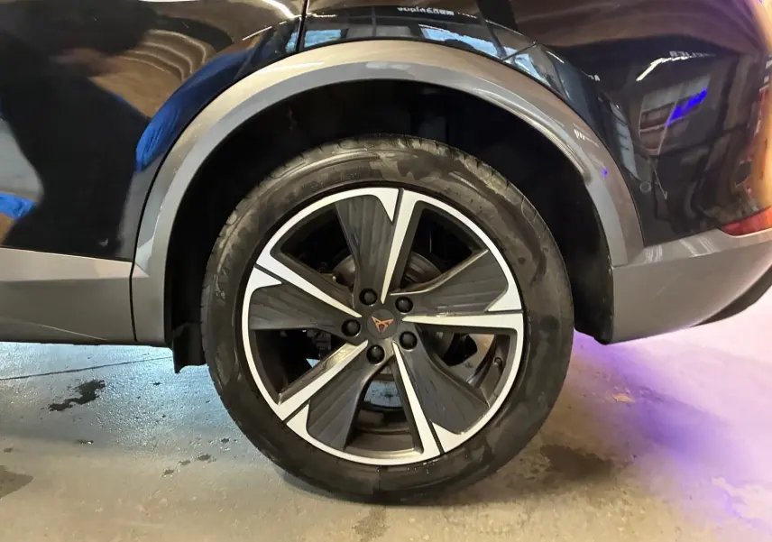 Gros plan sur la roue arrière droite d’un CUPRA Formentor noir avec jante alu bicolore et logo CUPRA central.