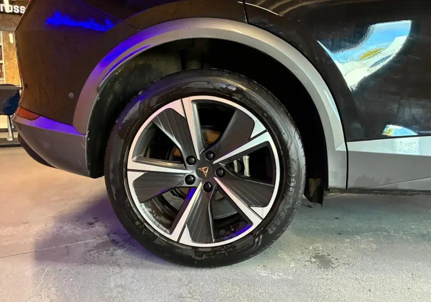 Gros plan sur la roue arrière droite d'une CUPRA Formentor noire avec jante alu bicolore et logo CUPRA central.