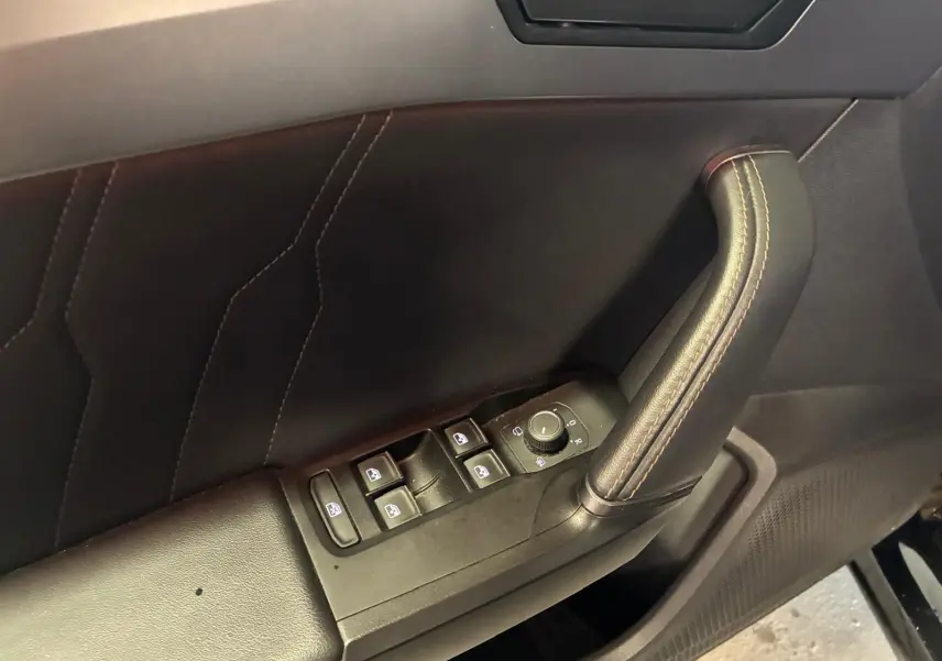 Gros plan sur la poignée de porte côté conducteur noire avec commandes des vitres et réglage des rétroviseurs du CUPRA Formentor 2022.