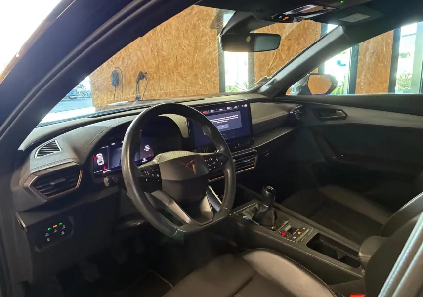 Vue intérieure côté conducteur de la CUPRA Formentor noire, avec volant multifonction, écran tactile et boîte manuelle.