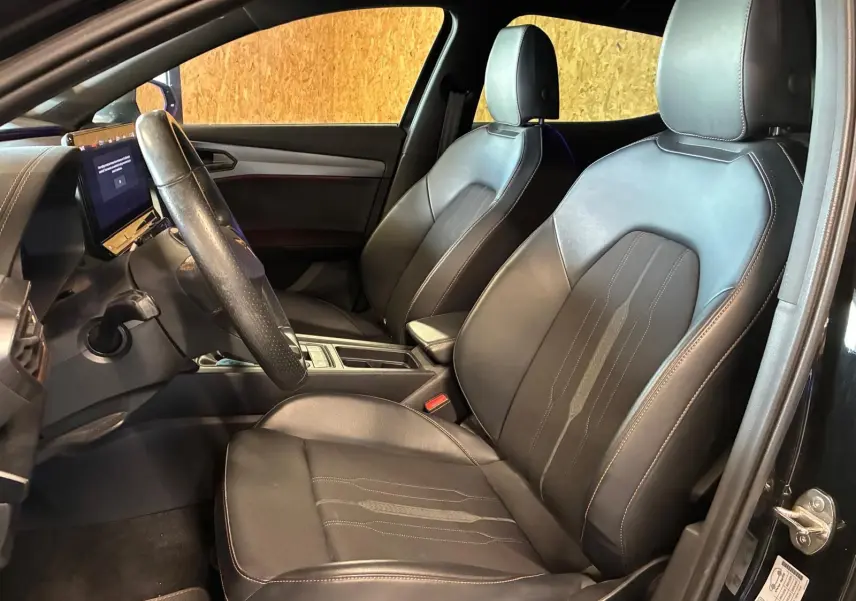 Vue intérieure côté conducteur de la CUPRA Formentor 2.0 TDI 150 V 2022 avec sièges noirs en tissu et cuir, tableau de bord moderne.