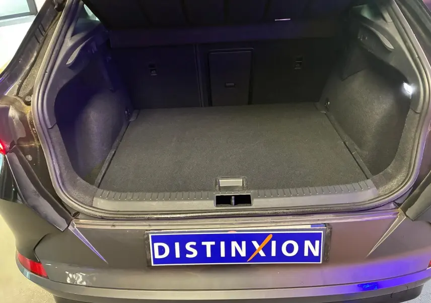 Coffre ouvert vu de l'arrière d'une CUPRA Formentor noire avec intérieur de coffre sombre et plaque Distinxion.