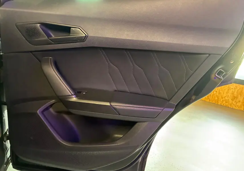 Vue rapprochée de la porte intérieure côté gauche du CUPRA Formentor noir, avec surpiqûres et poignée intégrée.