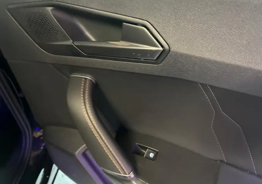 Détail de la porte intérieure côté gauche noire du CUPRA Formentor 2.0 TDI 150 V avec surpiqûres cuivrées.