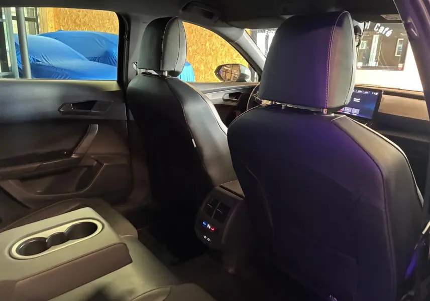 Vue intérieure arrière du CUPRA Formentor noir, montrant les sièges avant et la console centrale avec commandes climatisation.