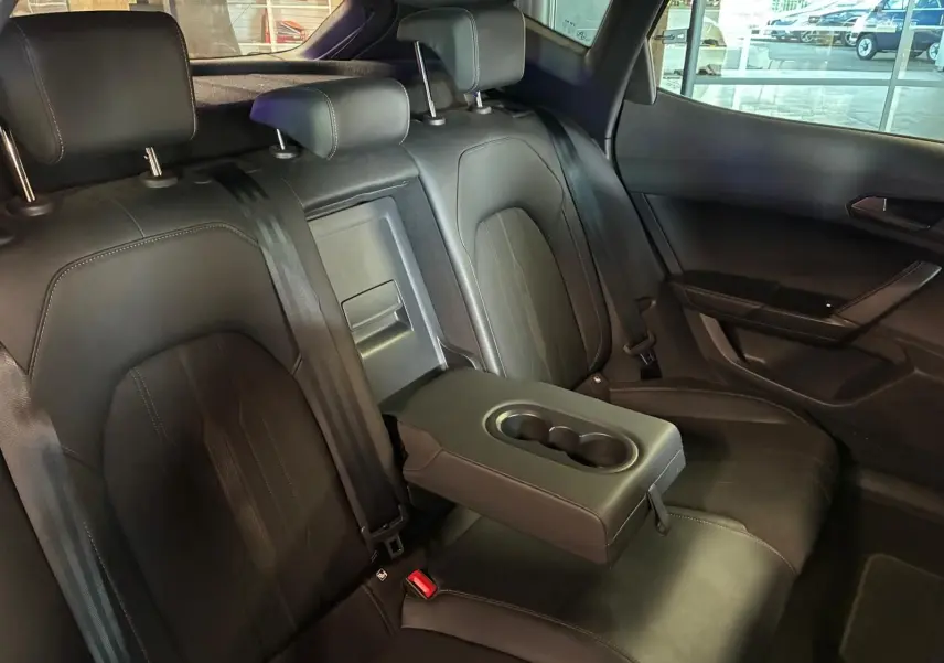 Vue intérieure des sièges arrière noirs du CUPRA Formentor 2.0 TDI 150 V avec accoudoir central et porte-gobelets déployé.