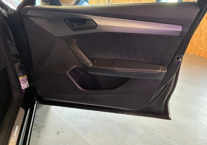 Vue intérieure de la porte avant gauche noire du CUPRA Formentor 2.0 TDI avec surpiqûres et insert aluminium.