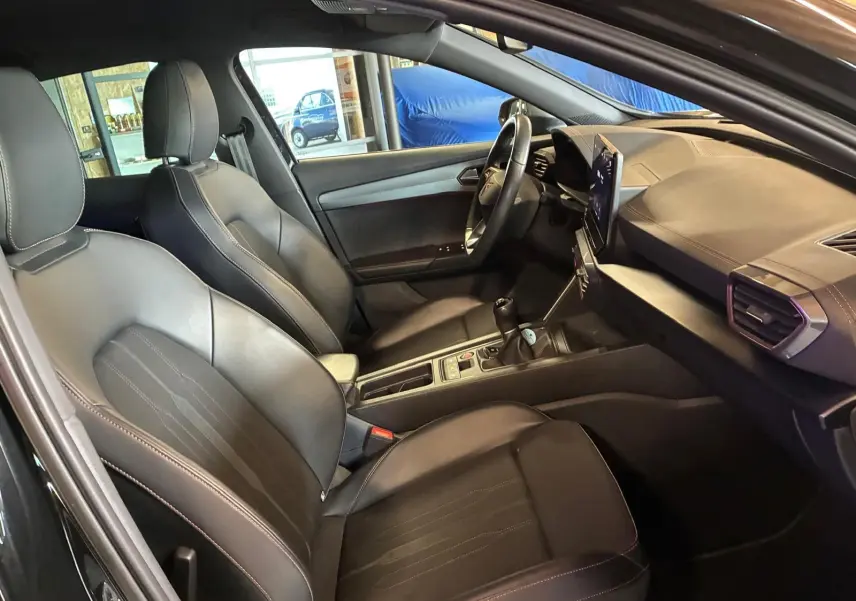 Vue intérieure côté conducteur du CUPRA Formentor noir, montrant sièges en cuir, tableau de bord et volant multifonction.