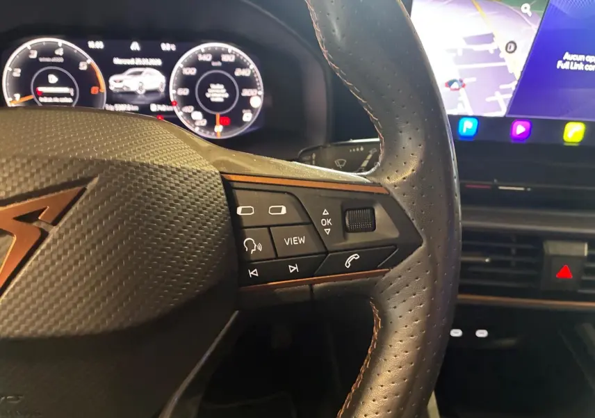 Gros plan sur le volant noir perforé de la CUPRA Formentor 2.0 TDI 150 V avec commandes multifonctions et tableau de bord numérique.