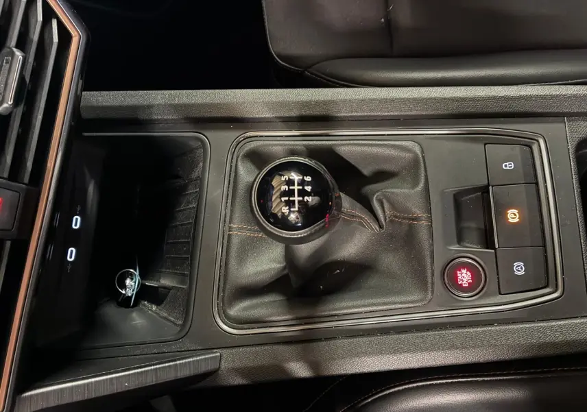 Vue plongeante sur la console centrale noire du CUPRA Formentor 2.0 TDI avec levier de vitesse manuel et bouton Start/Stop rouge.